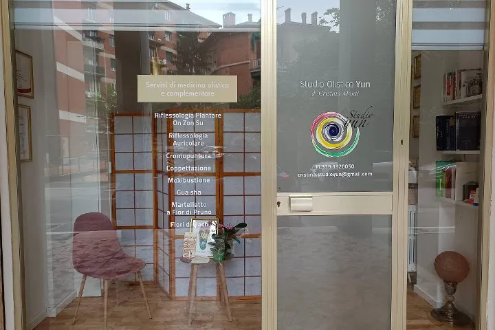 The entrance to the studio on Via San Rocco, with the logo and the list of treatments on the shop window